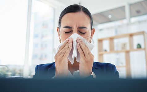 一位女商人在办公室工作时用纸巾擤鼻子、打喷嚏，感染了新冠病毒、病毒和病。