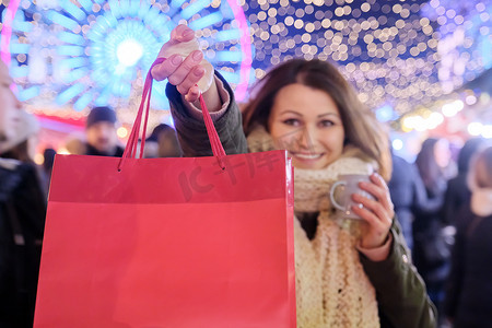 快乐的女人展示红色圣诞购物袋，专注于袋子，放置文字