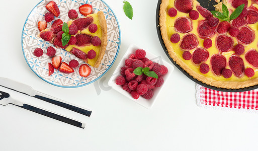 吃蛋饼摄影照片_白桌上有红草莓和覆盆子的圆形乳蛋饼
