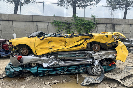 废品厂摄影照片_一堆被撕碎的汽车将在回收厂被撕碎，道路事故后一堆汽车。