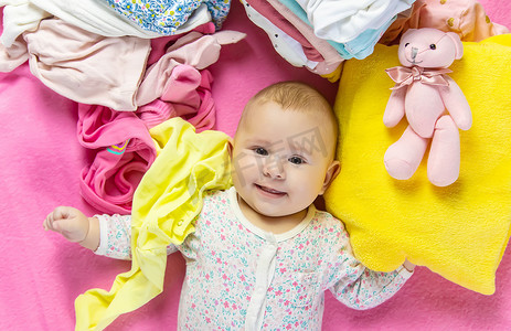 玩具凌乱摄影照片_婴儿的衣服和玩具散落一地。