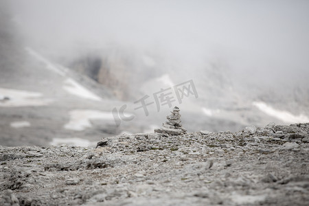 石凯摄影照片_小石标，Sella 上的一堆石头，Sass Pordoi，在多洛米蒂山脉中，有明亮的雾背景。