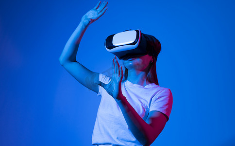 戴 VR 耳机的女性用手指触摸 VR 设备上的虚拟面板观看。 