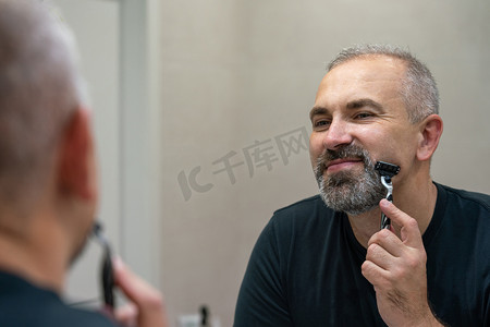 十里红妆摄影照片_中年帅哥在浴室里用剃须刀