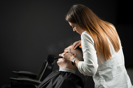 直剃刀在理发店给男人剪头发。