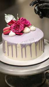 人像图标磨砂摄影照片_设计师用标志装饰磨砂丁香浪漫生日快乐蛋糕顶部