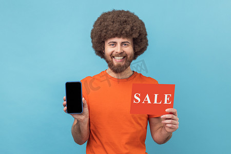 显示屏模板摄影照片_满意的男人手里拿着带空白显示屏和销售卡的智能手机，折扣申请。