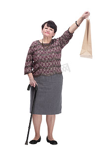 拄着拐杖的老人摄影照片_拄着拐杖和购物袋的老妇人。