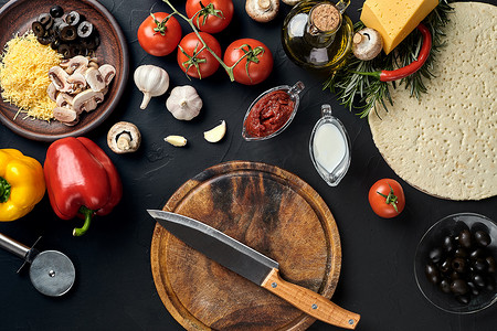 比萨原料摄影照片_用传统的比萨准备原料切割木板：奶酪、番茄酱、罗勒、橄榄油、胡椒、香料。