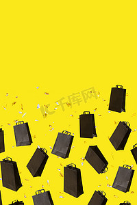 带有黑色销售购物袋的图案在带有复制空间的黄色背景上飞行。