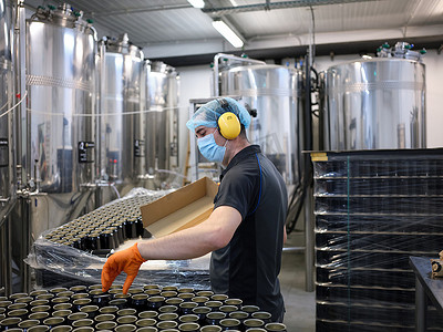 工人从啤酒厂精酿啤酒罐装生产线上拾罐