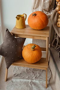 秋天花瓶摄影照片_摄影工作室的秋季室内装饰，配有南瓜、花瓶和木凳