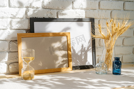 桌子上砖墙背景上的相框，花瓶里有麦穗