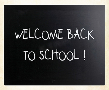 “欢迎回到学校”，用白色粉笔在黑色上手写