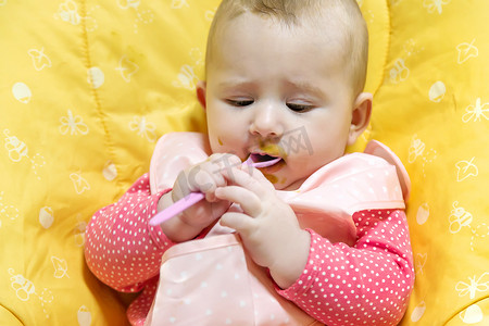 宝宝穿棉衣服摄影照片_宝宝正在吃蔬菜泥。
