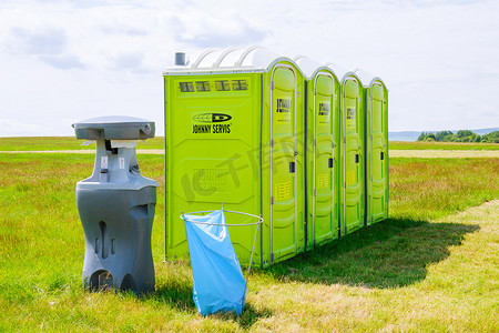 捷克共和国斯库泰克，2020年6月26日：云背景草地上的便携式厕所。