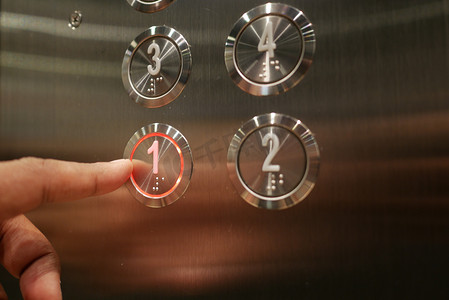 男子按下电梯按钮。