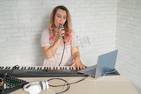 一位女士在家中使用笔记本电脑和键盘伴奏录制声乐课程。