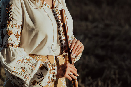 拿着木管乐器木笛的妇女-乌克兰telenka或tylynka。