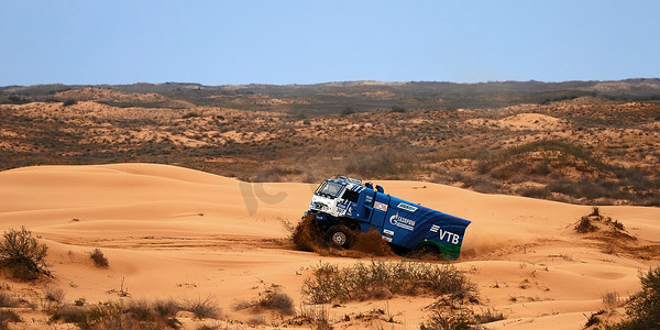 马路线摄影照片_运动卡车卡玛斯在沙地拉力赛中克服了路线上的困难部分。