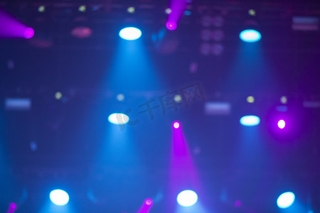 舞台光束背景摄影照片_蓝色舞台背景与白色和粉色投影仪光束。
