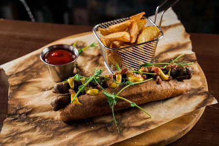 烤热狗摄影照片_烧烤烤热狗和啤酒，配有黄芥末和番茄酱，木质背景。