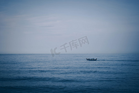 简单的背景 平静的深蓝色大海 渔船独自白色 苍白的浪花 开放的方式没有限制