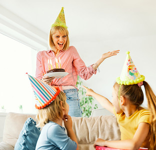 男孩女孩礼物摄影照片_孩子家庭生日庆祝派对蛋糕父亲快乐母亲女儿儿子父母男孩女孩一起开心蜡烛节日帽子礼物