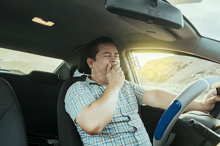 开心驾驶摄影照片_一位昏昏欲睡的司机在车里的景象。