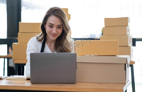开办小企业的肖像中小企业主女企业家在收据盒上工作，并检查在线订单，准备包装盒子，向客户销售，在线中小企业经营理念。