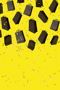 星期五黄色摄影照片_带有黑色销售购物袋的图案在带有复制空间的黄色背景上飞行。