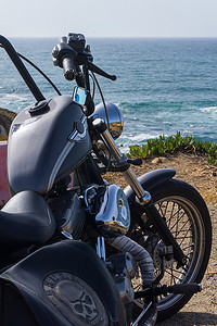 一辆摩托摄影照片_一辆黑色经典摩托车站在海边的悬崖上，特写