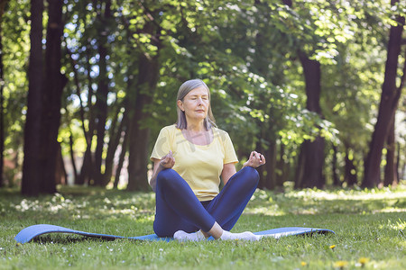 公园里白发退休的老妇人冥想并进行呼吸练习