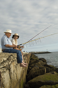 高级夫妇在海滩钓鱼