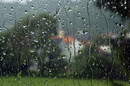 绿色滴落摄影照片_雨中透过汽车玻璃观看