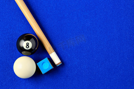 台球游戏摄影照片_蓝色台球桌上的台球、球杆和粉笔。