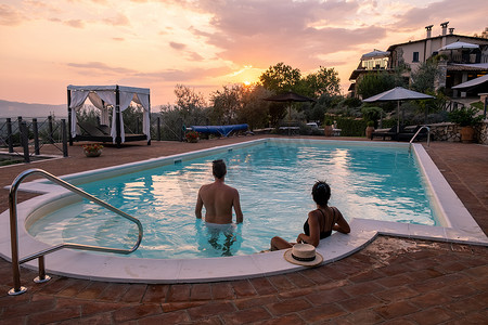 意大利带游泳池的豪华乡村别墅，意大利豪华别墅度假的情侣，男人和女人看日落