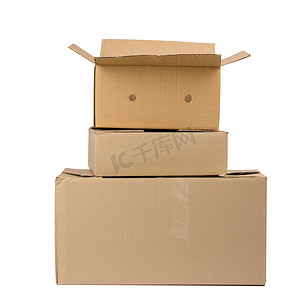 箱纸板摄影照片_白色背景上隔离的一叠封闭纸板棕色纸盒
