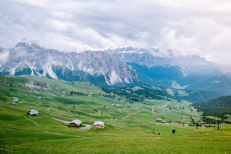 一对夫妇在意大利多洛米蒂山度假徒步旅行，欣赏塞塞达峰的壮丽景色。