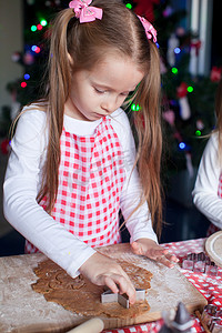 漂亮的小女孩用模具做圣诞节蛋糕