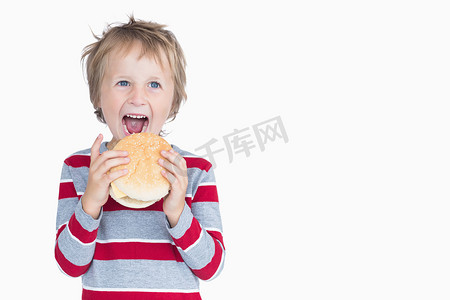 吃汉堡的快乐的小男孩