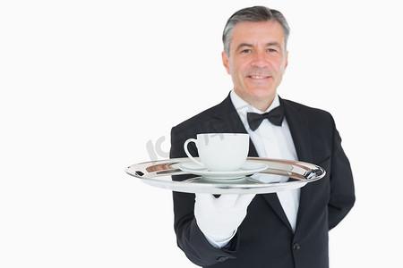 微笑的服务员拿着带咖啡杯的托盘