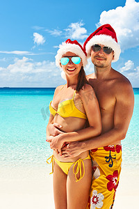 马尔代夫海滩上戴着圣诞老人帽子的夫妇