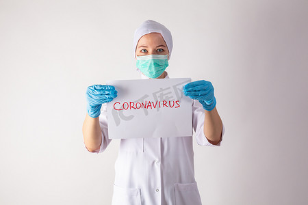 戴着面具的女医生手里拿着一块带有冠状病毒的药片。