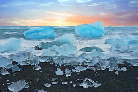 黄昏时分，冰岛 Jokulsarlon 黑沙滩上的冰岩