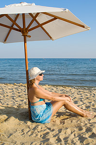 海滩上太阳伞下的女人
