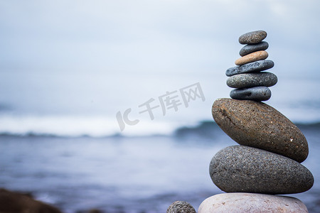 平衡、放松和健康：外面的石标，模糊背景中的海洋