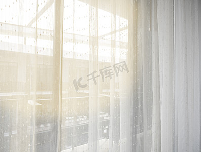 城市的卧室里清晨的阳光透过白色的窗帘，给人一种幸福、清新、温馨的感觉。