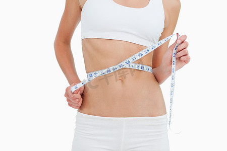 一位正在节食的女性测量腰围的特写