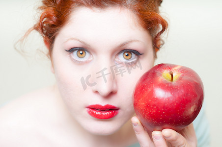 美丽的红头发和嘴唇女孩与苹果